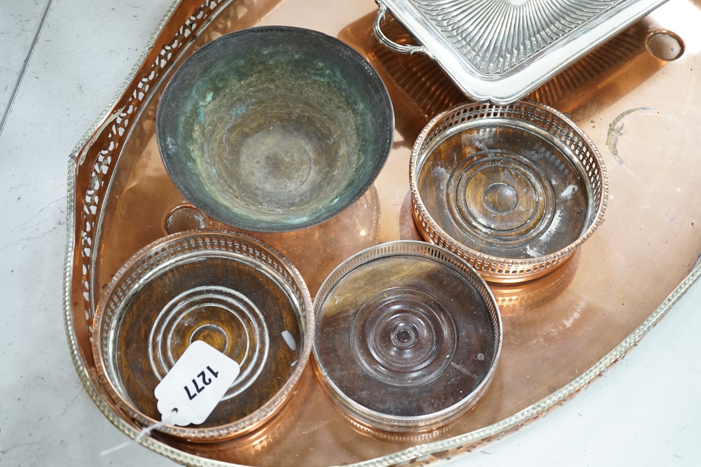 Three copper coasters, an oval tray plated bowl and entree dish